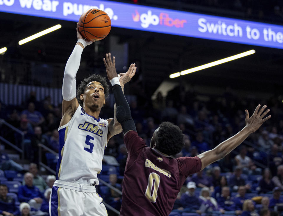 James Madison guard Terrence Edwards Jr. (5) takes a shot against Texas State guard Dylan Dawson (0) during the first half of an NCAA college basketball game in Harrisonburg, Va., Saturday, Dec. 30, 2023. (Daniel Lin/Daily News-Record via AP)