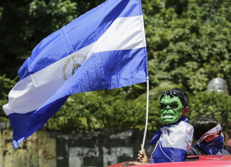 A masked boy waves a nicaraguan flag during a protest against Nicaraguan President Daniel Ortega's government in Managua, on September 16, 2018