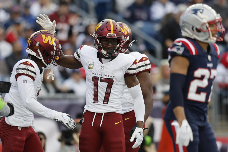 Washington Commanders wide receiver Jahan Dotson, left, celebrates his touchdown with wide receiver Terry McLaurin, center, as New England Patriots cornerback Myles Bryant, right, walks away in the second half of an NFL football game, Sunday, Nov. 5, 2023, in Foxborough, Mass. (AP Photo/Michael Dwyer)