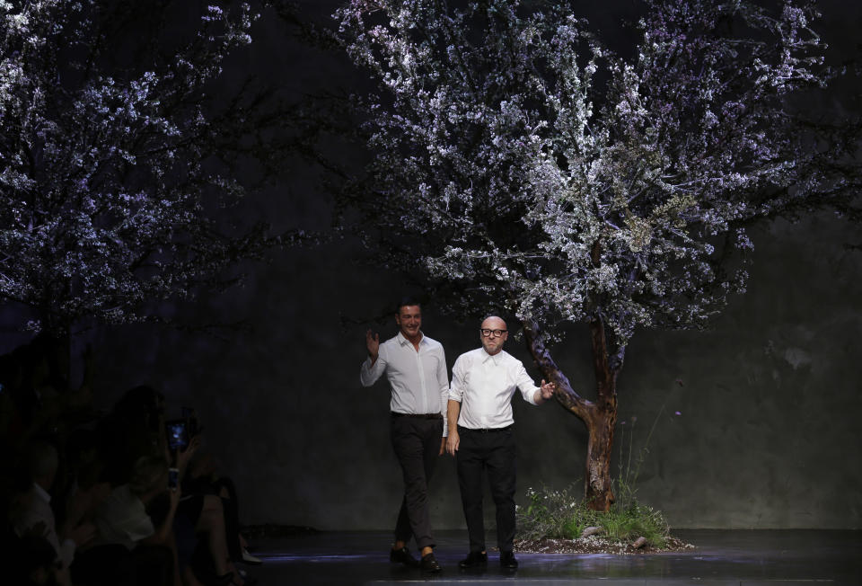 Italian fashion designers Domenico Dolce, right, and Stefano Gabbana wave on the catwalk at the end of their Dolce & Gabbana women's Spring-Summer 2014 fashion show, part of the Milan Fashion Week, unveiled in Milan, Italy, Sunday, Sept. 22, 2013. (AP Photo/Luca Bruno)