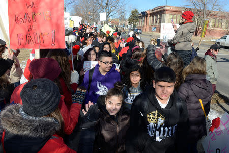 Students exchange high fives with teachers as they walk out of their classes in support of their teachers, who are on strike for a second day, in Denver, Colorado, U.S., February 12, 2019. REUTERS/Michael Ciaglo