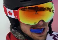 Another snowboarder is seen reflected in the visor of Canada's Matthew Morison during the men's snowboard parallel giant slalom qualification run at the 2014 Sochi Winter Olympic Games in Rosa Khutor February 19, 2014. REUTERS/Dylan Martinez (RUSSIA - Tags: OLYMPICS SPORT SNOWBOARDING)