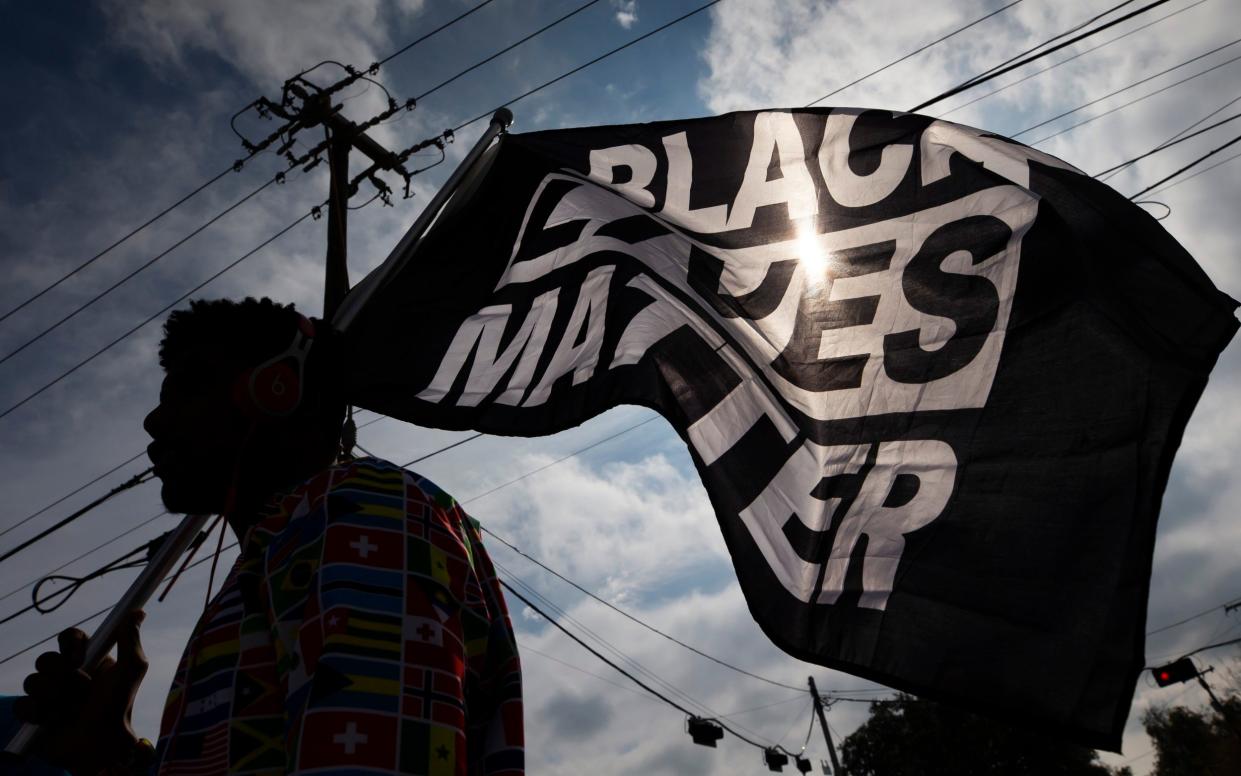 MD Crawford carries a Black Lives Matter flag before a march in La Marque, Texas - Stuart Villanueva/The Galveston County Daily News via AP