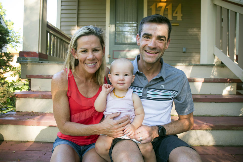 In this undated photo, three-time Ironman world champion Mirinda Carfrae, left, and her husband, elite triathlete Tim O'Donnell pose with their 1-year-old daughter Isabelle during a break in their training camp in Lawrence, Kan. Carfrae and O'Donnell are among the favorites for next month's Ironman world championships in Kona, Hawaii (Talbot Cox via AP)