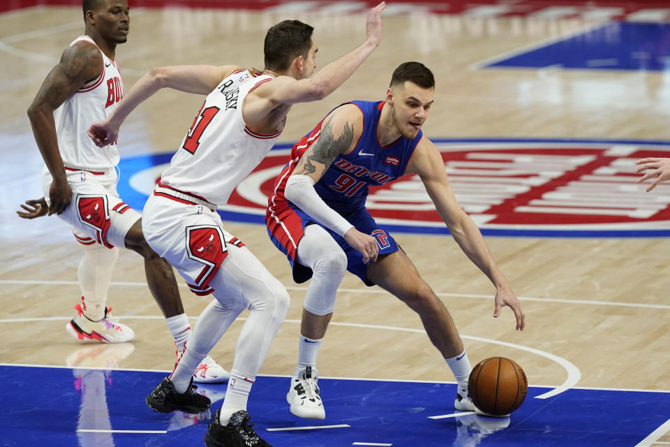 Detroit Pistons guard Deividas Sirvydis (91) controls the ball next to Chicago Bulls guard Tomas Satoransky (31) during the first half of an NBA basketball game, Sunday, May 9, 2021, in Detroit. (AP Photo/Carlos Osorio)