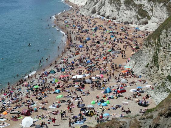 The beach at Durdle Door was crowded on Saturday, while people have been allowed to go outside as long as they keep their distance from others (Andrew Matthews/PA Wire)