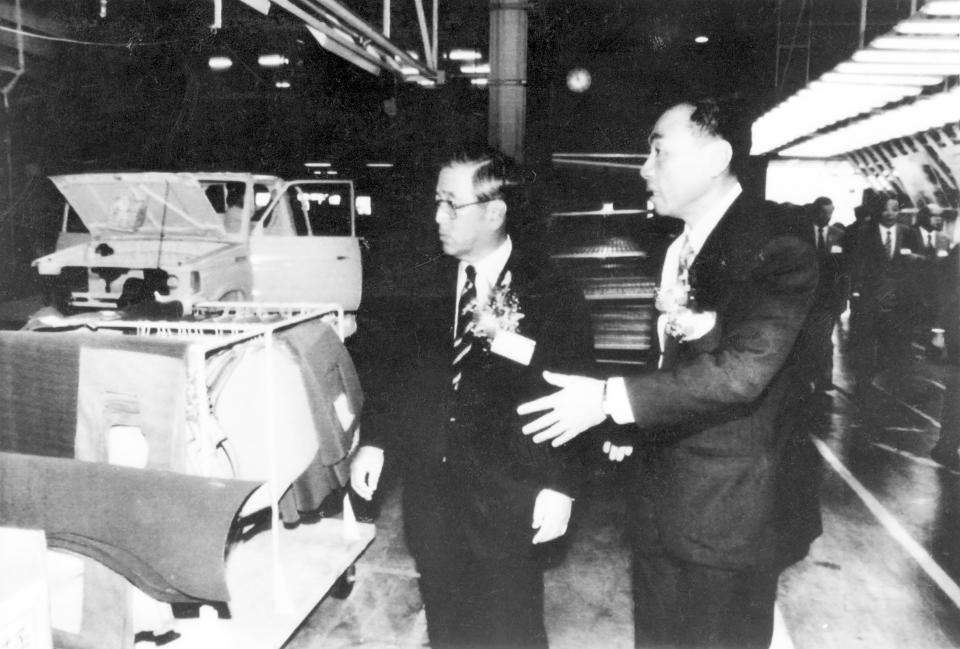 FILE - Shoichiro Toyoda, then chairman of Japan's Toyota Motor Corp., left, inspects a production line of light trucks at a Taiwan-Toyota joint venture plant Saturday, Sept. 17, 1988. Toyoda, who as a son of the company's founder oversaw Toyota's expansion into international markets has died. He was 97. (AP Photo/Yang Chi-hsien, File)