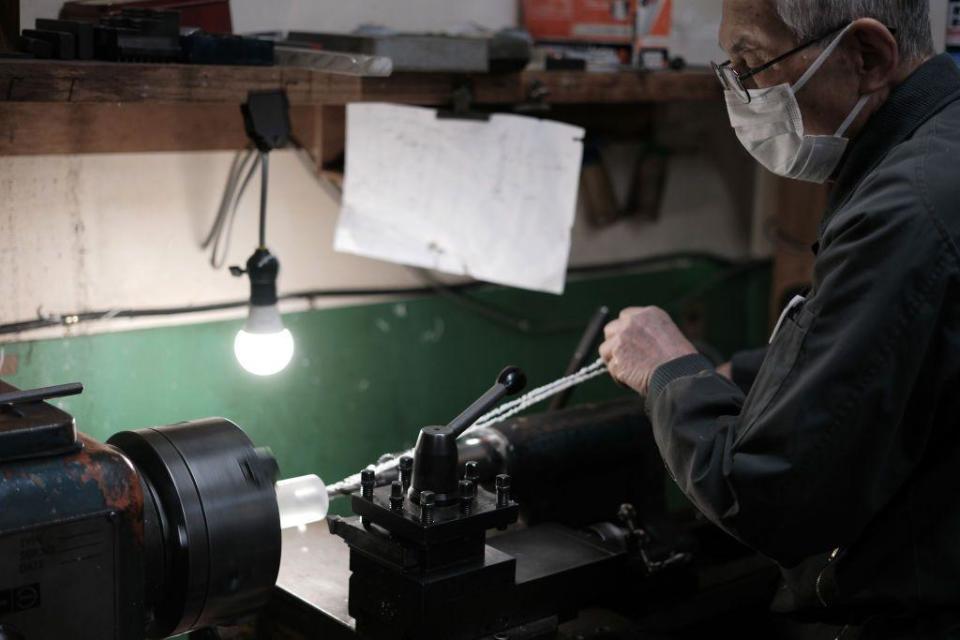 A worker wearing a mask in a Japanese factory. 