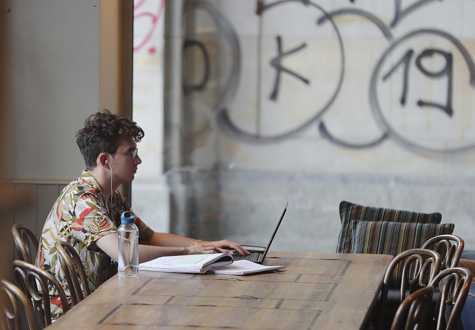 A Polish man works on a laptop in a cafe in Warsaw, Poland, Thursday, Aug. 1, 2019.Poland on Thursday scrapped its personal income tax for young employees earning less than dollars 22,000 a year, as part of a drive to reverse a brain drain and demographic decline that's dimming the prospects of a country that is otherwise experiencing strong economic growth.(AP Photo/Czarek Sokolowski)