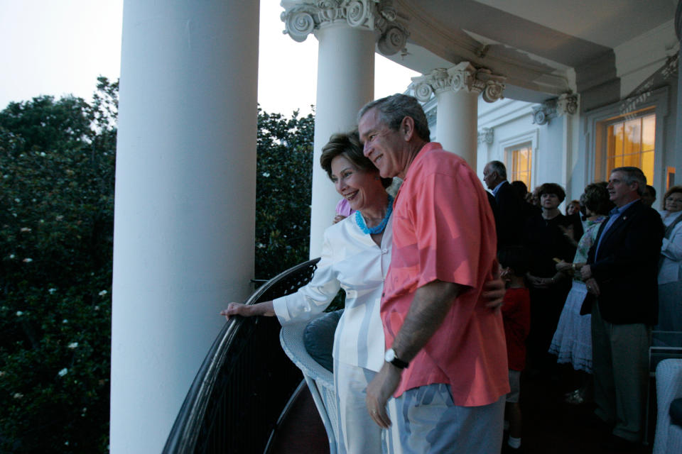 This photograph shows President George W. Bush and First Lady Laura Bush standing with guests on the Truman Balcony during the 2005 4th of July celebration.