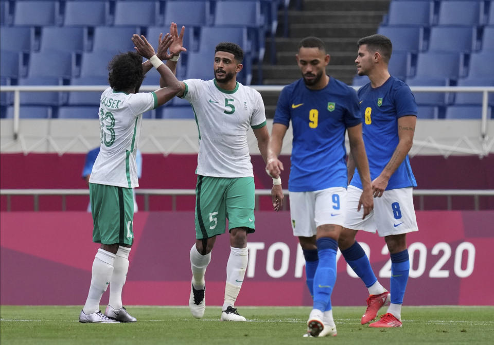 Saudi Arabia's Abdulelah Alamri, second left, celebrates with his teammate Yasser Alshahrani after scored his side's first goal against Brazil during a men's soccer match at the 2020 Summer Olympics, Wednesday, July 28, 2021, in Saitama, Japan. (AP Photo/Martin Mejia)