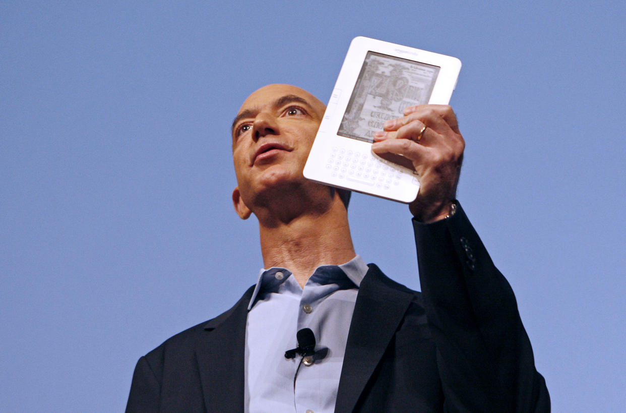 Amazon.com founder and CEO Jeff Bezos holds the new Kindle 2 electronic reader at a news conference in New York where the device was introduced, February 9, 2009. The Kindle 2, the latest incarnation of the digital book reader is a slimmer version with more storage and a feature that reads text aloud to users.  REUTERS/Mike Segar  (UNITED STATES)