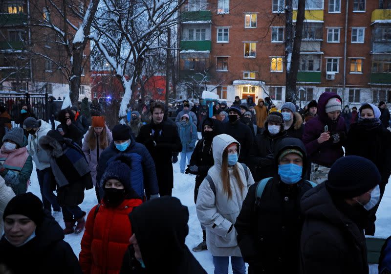 People, including supporters of Alexei Navalny, gather outside a police station where the opposition leader is being held following his detention, in Khimki