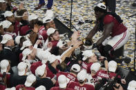 Alabama offensive lineman Alex Leatherwood holds the trophy for his teammates to touch after an NCAA College Football Playoff national championship game against Ohio State, Tuesday, Jan. 12, 2021, in Miami Gardens, Fla. Alabama won 52-24. (AP Photo/Wilfredo Lee)