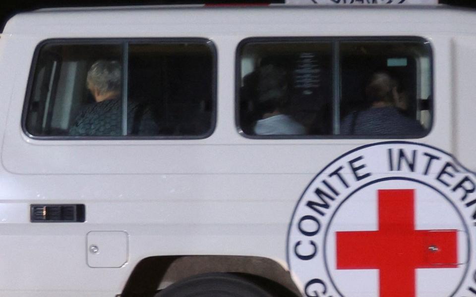 A Red Cross vehicle, as part of a convoy believed to be carrying hostages abducted by Hamas militants during the October 7 attack on Israel, arrives at the Rafah border, amid a hostages-prisoners swap deal between Hamas and Israel, as seen from southern Gaza Strip November 24, 2023. REUTERS/Ibraheem Abu Mustafa