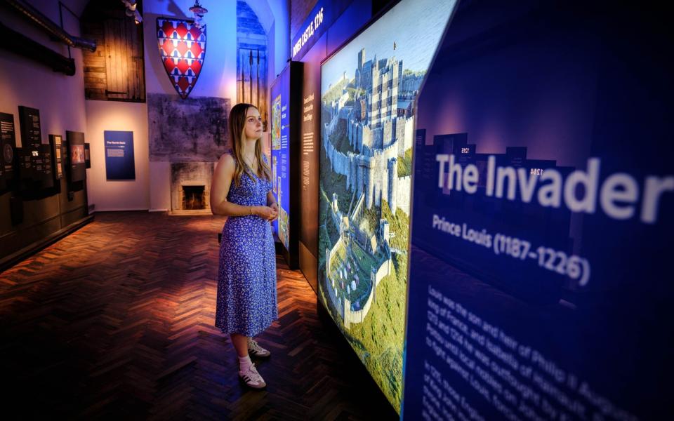 Woman stands next to an information board in the castle