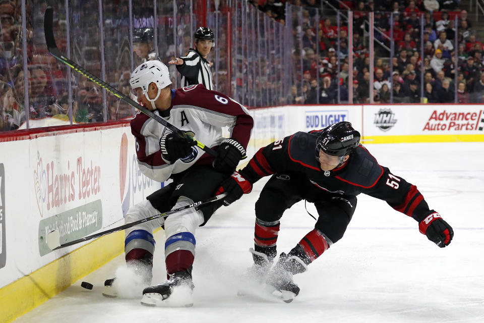 Colorado Avalanche's Erik Johnson (6) battles with Carolina Hurricanes' Jake Gardiner (51) during the first period of an NHL hockey game in Raleigh, N.C., Friday, Feb. 28, 2020. (AP Photo/Karl B DeBlaker)