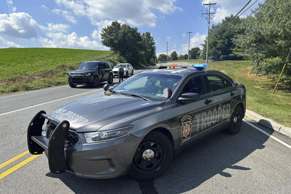 Police vehicles block a road near Chester County Prison where convicted murderer Danelo Cavalcante escaped last week as they continue to search for him, Wednesday, Sept. 6, 2023, in Pocopson Township, Pa. Officials expanded the zone they're searching for him after he was spotted on cameras at Longwood Gardens, a botanical garden in the area. (AP Photo/Tassanee Vejpongsa)