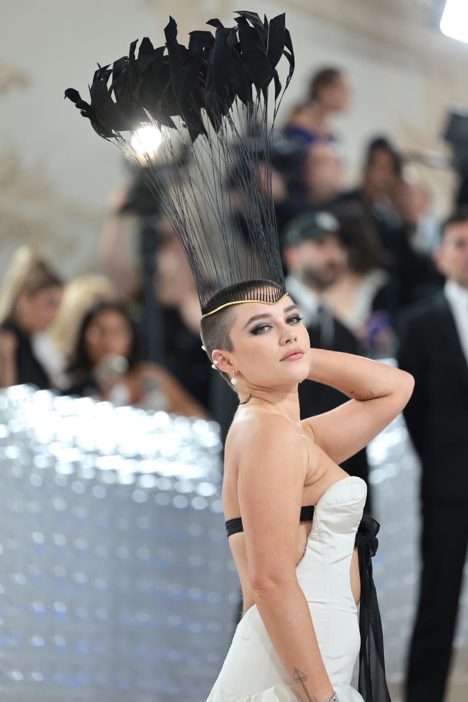 Florence rocking a shaved head and a tall headpiece on the red carpet