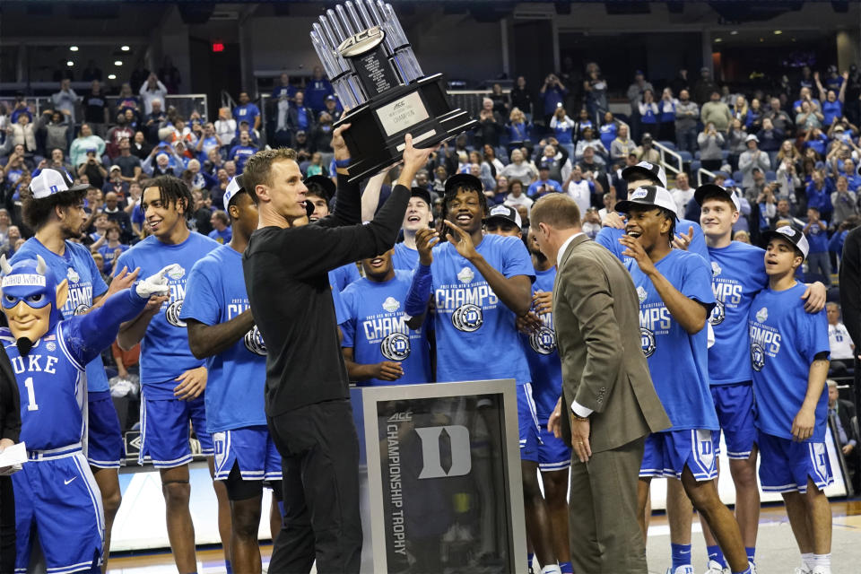Duke head coach Jon Scheyer holds up the trophy after Duke's win over Virginia in an NCAA college basketball game for the championship of the Atlantic Coast Conference tournament in Greensboro, N.C., Saturday, March 11, 2023. (AP Photo/Chuck Burton)