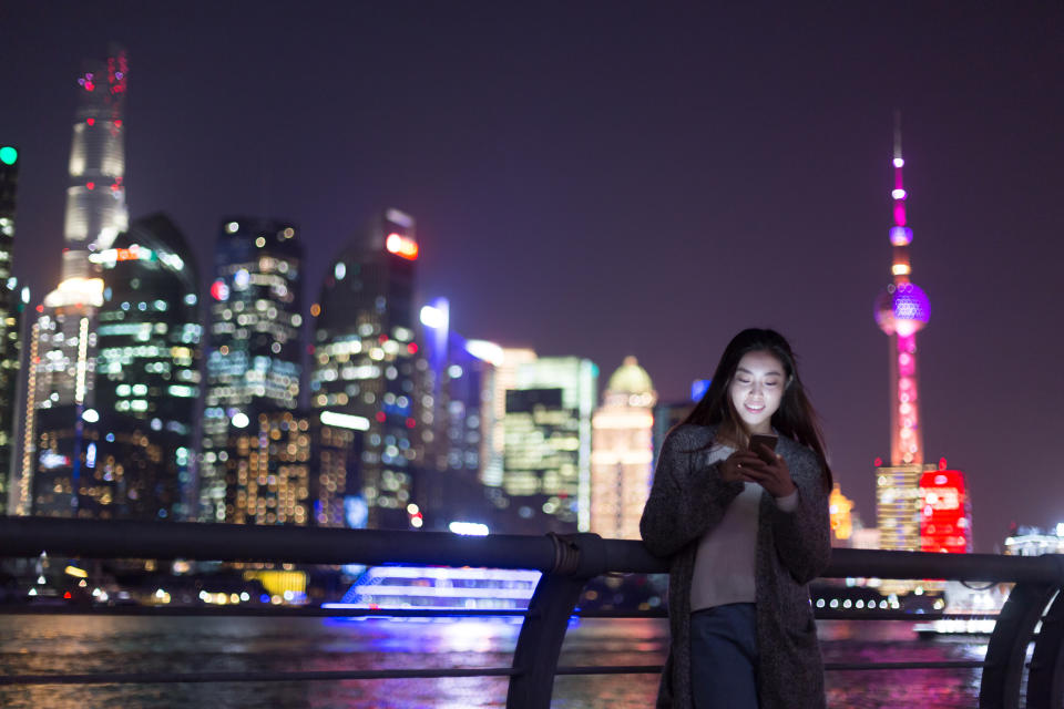 Young Chinese woman using phone in Shanghai