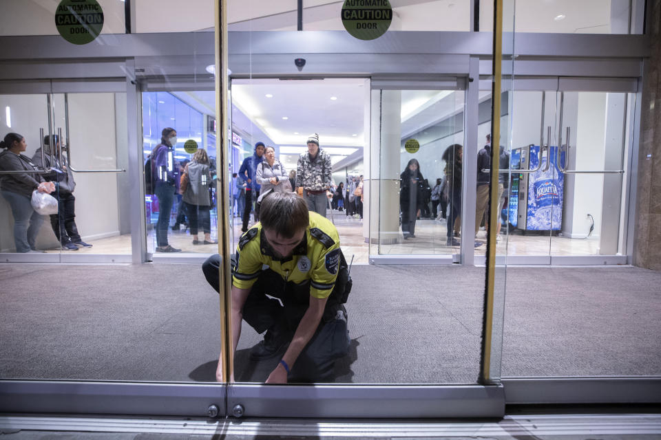 Security supervisor Travis Morin locks the doors to the Galleria at Sunset shopping mall at 7 p.m. in Henderson, Nev. Tuesday, Nov. 8, 2022. A long line of voters remained in the mall as the polls closed. (Steve Marcus/Las Vegas Sun via AP)