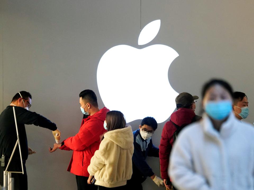 FILE PHOTO: People wearing protective masks wait for checking their temperature in an Apple Store, in Shanghai, China, as the country is hit by an outbreak of the novel coronavirus, February 21, 2020. REUTERS/Aly Song/File Photo