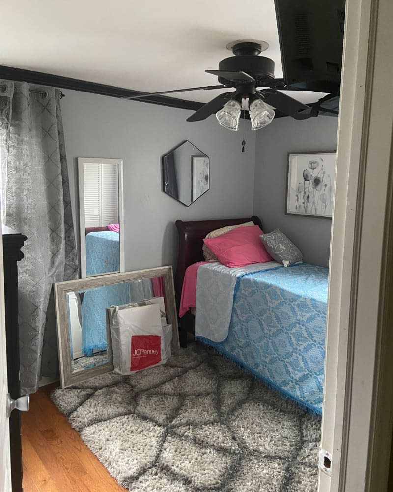 Neatly made bed in bedroom before remodel.