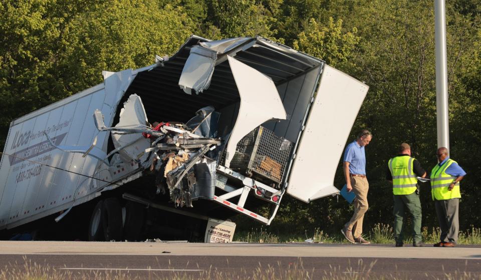 Officials survey a damaged tractor-trailer before removing it from the scene on Wednesday, July 12, 2023, on westbound Interstate 70 after it collided with a Greyhound bus near Highland, Ill. (Christian Gooden/St. Louis Post-Dispatch via AP)