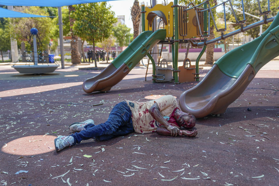 A supporter of the Eritrean government lies injured and covered in blood after he was hurt by an Anti-Eritrean government activist, during a protest against an event organized by the Eritrea Embassy in Tel Aviv, Israel, Saturday, Sept. 2, 2023. Hundreds of Eritrean asylum seekers smashed shop windows and police cars in Tel Aviv on Saturday and clashed with police during a protest against an event organized by the Eritrea Embassy. The Israeli police said 27 officers were injured in the clashes, and at least three protesters were shot when police opened fire with live rounds when they felt "real danger to their lives." (AP Photo/Ohad Zwigenberg)