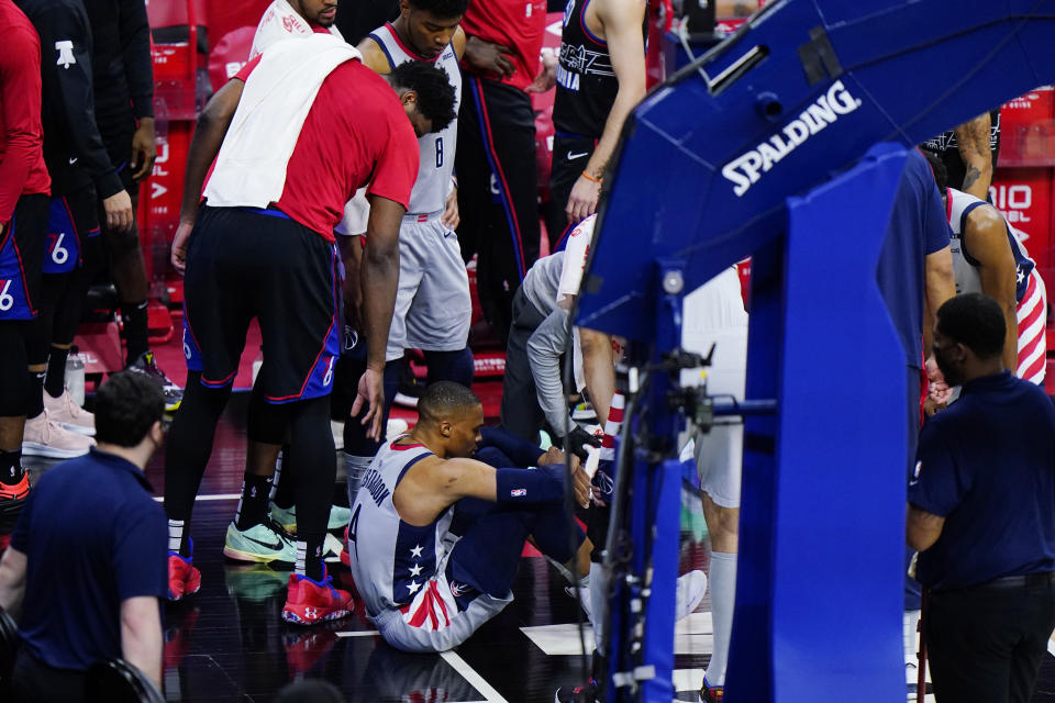 Philadelphia 76ers' Joel Embiid, left, checks on Washington Wizards' Russell Westbrook after an injury during the second half of Game 2 in a first-round NBA basketball playoff series, Wednesday, May 26, 2021, in Philadelphia. (AP Photo/Matt Slocum)