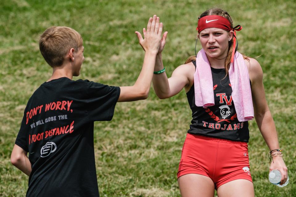 Tusky Valley's Hannah Wyler gets a high five after competing in the girls 1600 meter run during the Division II East District Track and Field Meet Saturday at West Holmes High School.