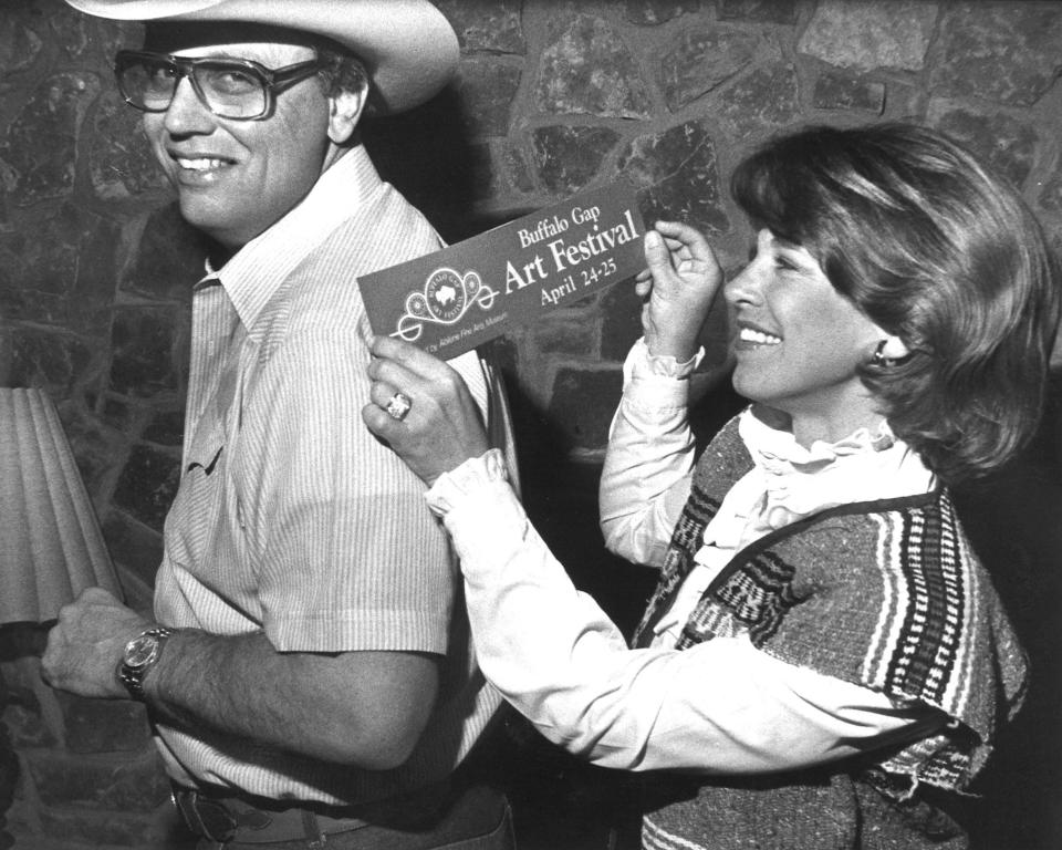 Judy Colvin considers placing a Buffalo Gap Art Festival sticker on the back of her husband, former NFL player Jim Colvin, during event promotion in 1982.