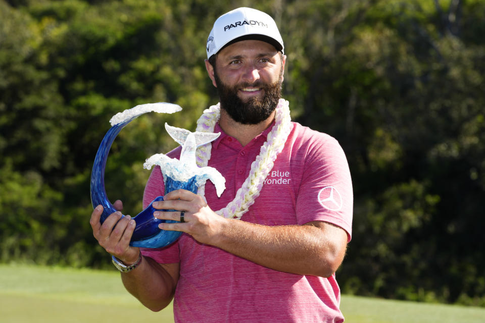 Jon Rahm, of Spain, holds the champions trophy after the final round of the Tournament of Champions golf event, Sunday, Jan. 8, 2023, at Kapalua Plantation Course in Kapalua, Hawaii. (AP Photo/Matt York)