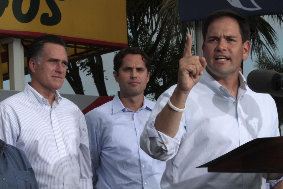 Republican presidential candidate, former Massachusetts Gov. Mitt Romney, left, and his son Craig, center, listen as Sen. Marco Rubio R-Fla., speaks at a campaign event at El Palacio de los Jugos, Monday, Aug. 13, 2012, in Miami, Fla. (AP Photo/Mary Altaffer)