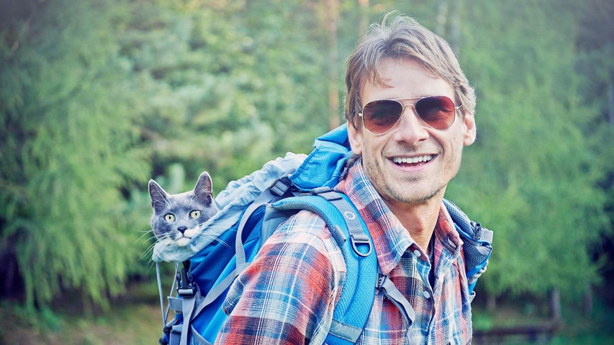  Man hiking with cats in backpack 