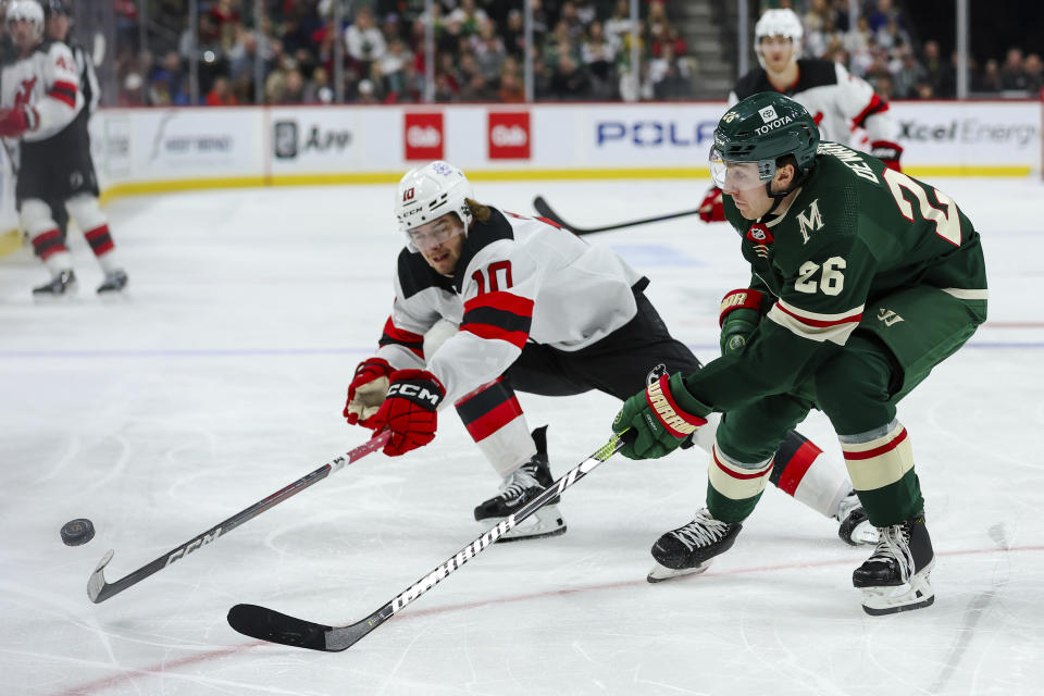 Minnesota Wild center Connor Dewar, right, and New Jersey Devils right wing Alexander Holtz (10) compete for the puck during the second period of an NHL hockey game, Thursday, Nov. 2, 2023, in St. Paul, Minn. (AP Photo/Matt Krohn)