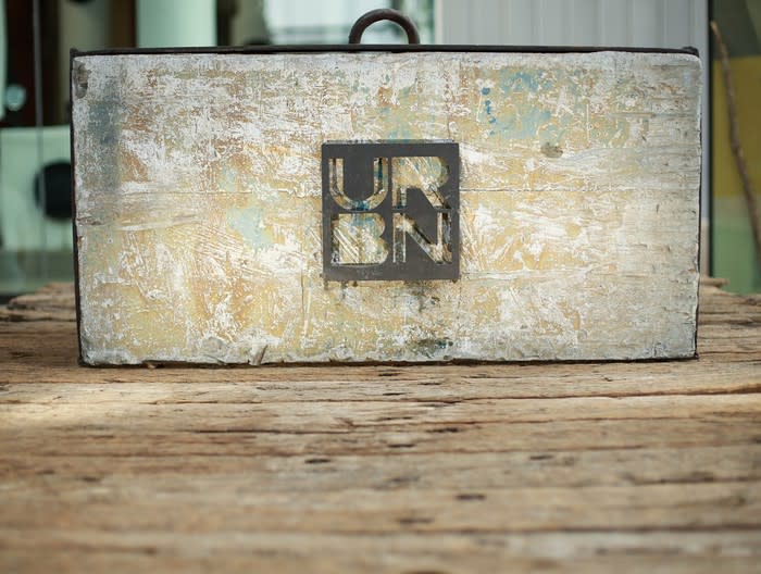 Box with handle and URBN logo on a wood table.