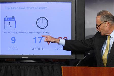 U.S. Senator Chuck Schumer (D-NY) points to a countdown clock at a news conference at the U.S. Capitol in Washington, September 30, 2013. REUTERS/Jonathan Ernst (UNITED STATES - Tags: POLITICS)