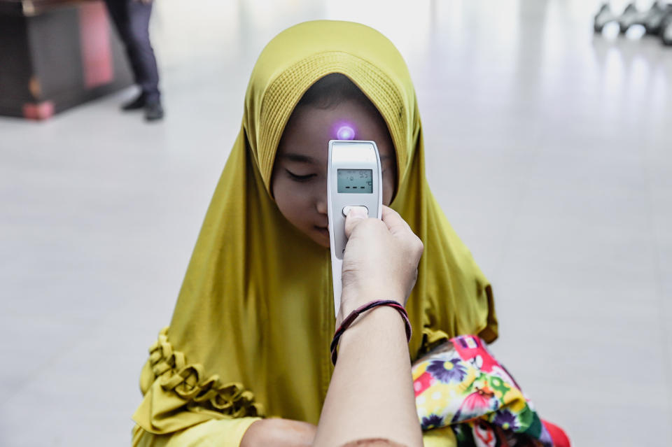 PALEMBANG, INDONESIA - MARCH 06 : An officer using a thermal scanner checks the temperature of passengers as a precaution against the coronavirus (Covid-19) at the Kertapati Train Station in Palembang, Indonesia on March 06, 2020. The Indonesian confirmed its first Coronavirus (COVID-19) cases on March 02. (Photo by Muhammad A.F/Anadolu Agency via Getty Images)