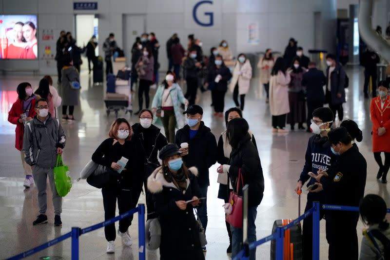 Passengers wearing masks are seen at the Pudong International Airport in Shanghai