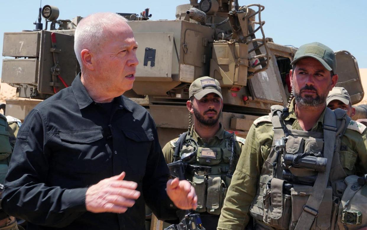 Israeli Defence Minister Yoav Gallant standing with soldiers by a self-propelled artillery howitzer during a visit to a position along the border with the Gaza Strip in southern Israel near Rafah