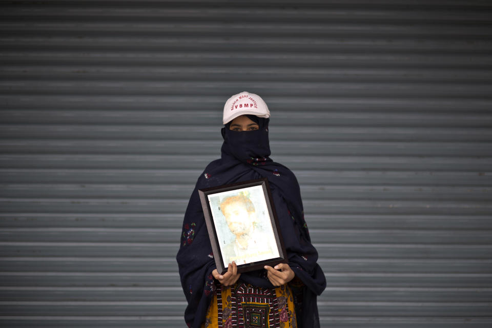 Robi Zarmen poses for a portrait holding a photograph of her dead brother, who went missing on February 11, 2011, and a year after was reported dead, while she and other relatives take a break from a long march protest, in Rawalpindi, Pakistan, Friday, Feb. 28, 2014. She is part of a group of activists from the impoverished southwestern province of Baluchistan who walked roughly 3,000 kilometers (1,860 miles) to the capital of Islamabad to draw attention to alleged abductions of their loved ones by the Pakistani government. (AP Photo/Muhammed Muheisen)