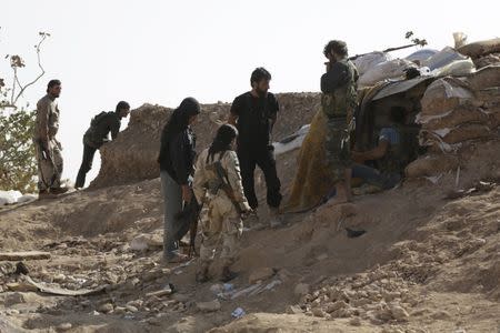 Free Syrian Army fighters of the 101 Division stand behind sandbags near the town of Morek in the northern countryside of Hama, Syria October 14, 2015. REUTERS/Khalil Ashawi