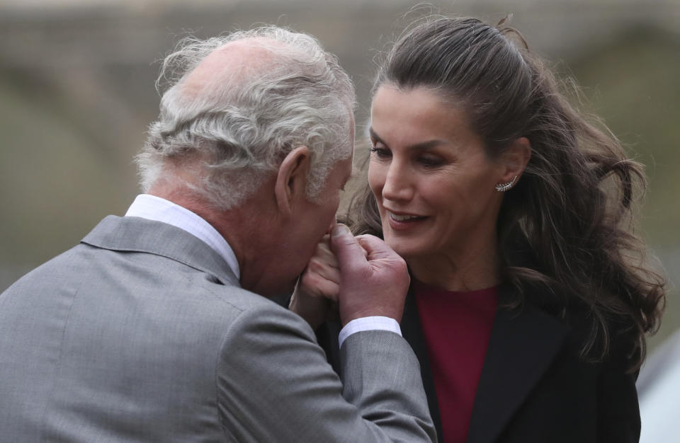 FILE - Britain's Prince Charles kisses the hand of Queen Letizia of Spain as they greet each other on a visit Auckland Castle to view the The Spanish Gallery, in Bishops Auckland, England, Tuesday, April 5, 2022. Spain’s Queen Letizia turned 50 on Thursday, Sept. 15, 2022. Spain is taking the opportunity to assess its scarred monarchy and ponder how the arrival of a middle-class commoner may help shake one of Europe’s most storied royal dynasties into a modern and more palatable institution. (AP Photo/Scott Heppell, File)