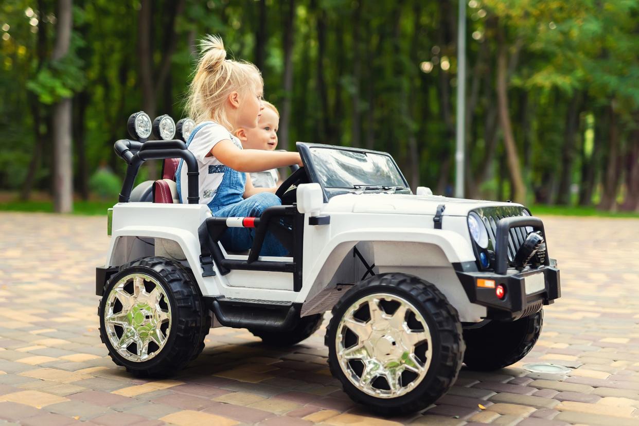 two small children in electric toy jeep