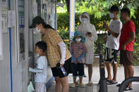 In this photo released by Xinhua News Agency, tourists wearing face masks wait in line to get their COVID-19 test at a coronavirus testing site in Sanya in south China's Hainan Province on Sunday, Aug. 7, 2022. The capital of China's Hainan province has locked down its residents for 13 hours as a COVID-19 outbreak grows on the tropical island during the summer school holidays. (Guo Cheng/Xinhua via AP)