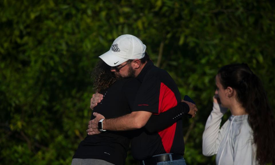 People embrace at the scene where five young adults were found dead in a submerged vehicle in a pond on Topgolf Way in Fort Myers on Monday, June 26, 2023. 