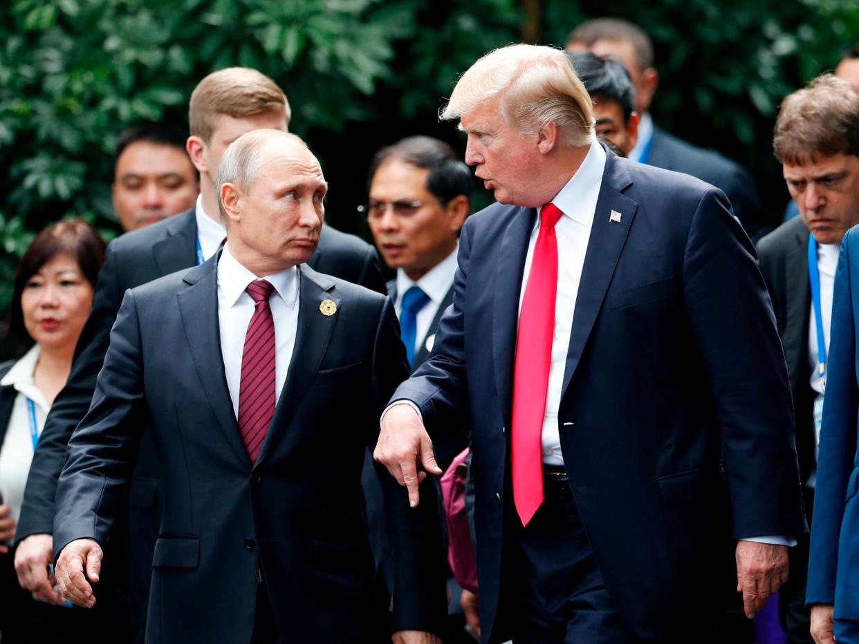 trump putin apec summit US President Donald Trump (R) and Russia's President Vladimir Putin talk as they make their way to take the "family photo" during the Asia-Pacific Economic Cooperation (APEC) leaders' summit in the central Vietnamese city of Danang on November 11, 2017. World leaders and senior business figures are gathering in the Vietnamese city of Danang this week for the annual 21-member APEC summit. / AFP PHOTO / POOL / JORGE SILVA (Photo credit should read JORGE SILVA/AFP via Getty Images)