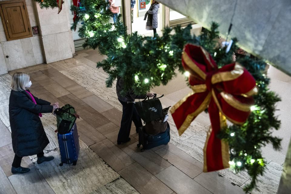 Travelers arrive to get their train from Grand Central Station in New York, Thursday, Dec. 21, 2023. (AP Photo/Eduardo Munoz Alvarez)